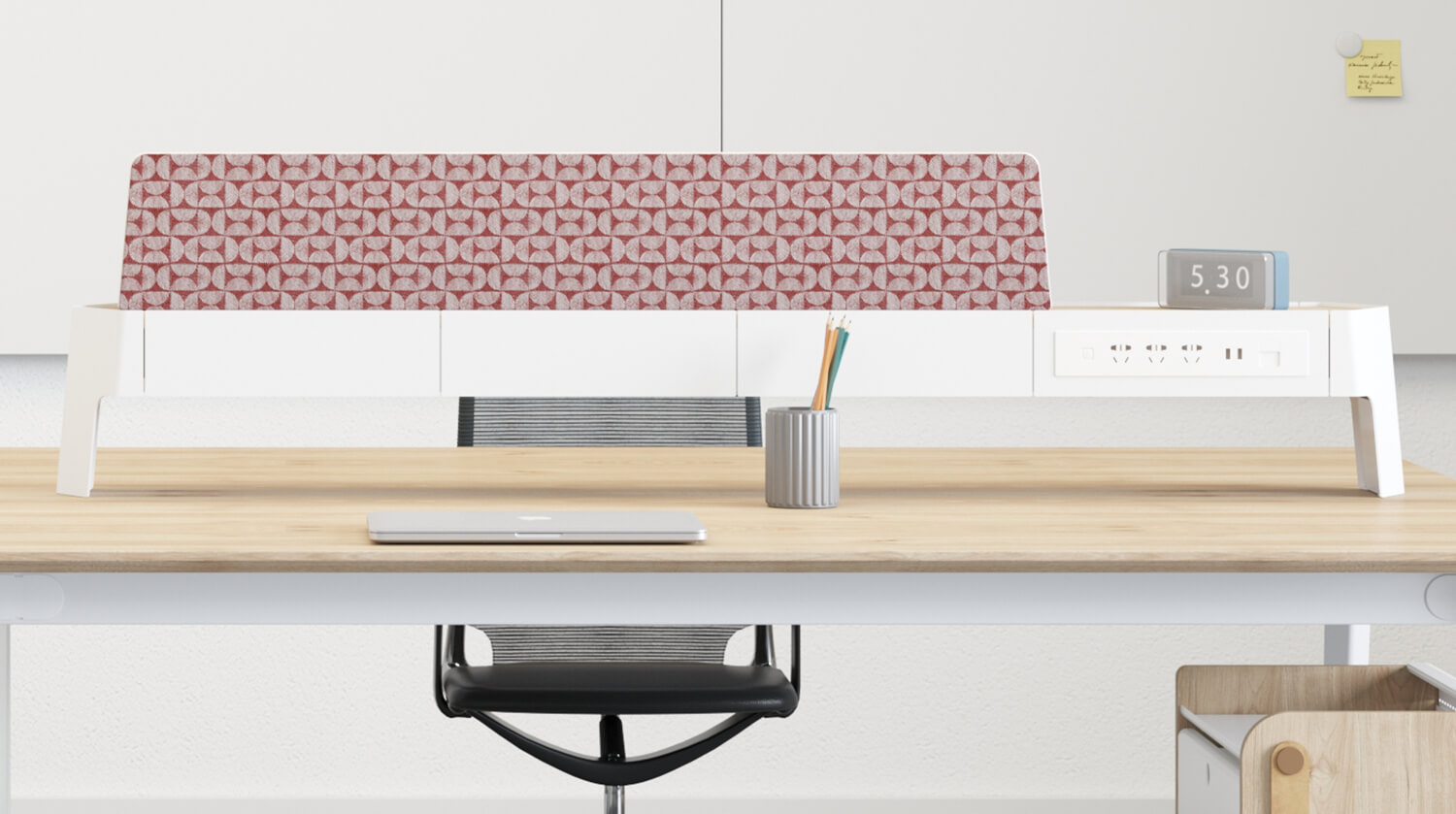 Patterned divider above a wood-grain workstation top, with a power outlet strip and steel frame